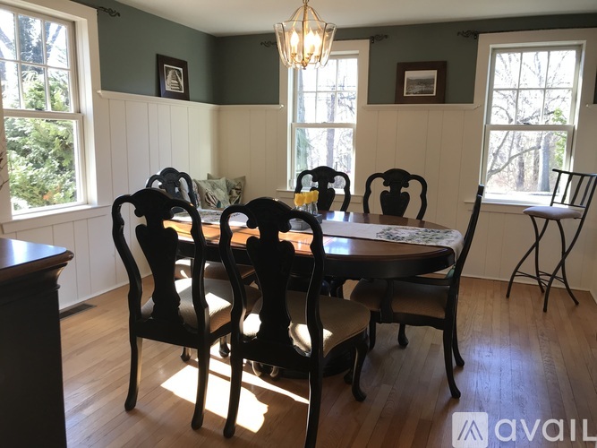 A dining room with a table and chairs.