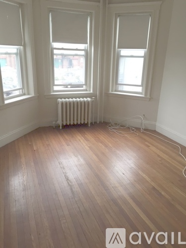 A room with wooden floors and two windows.