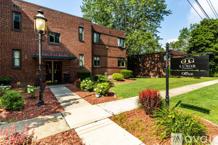 A brick building with a sign that says "LUXOR Office".