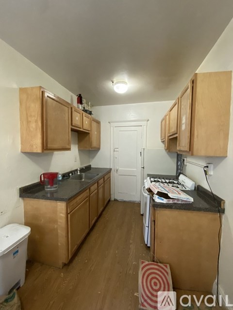 A kitchen with wooden cabinets and a white door.