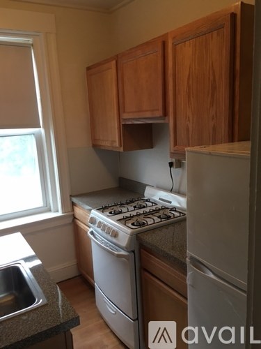 A kitchen with wooden cabinets and a stove top oven.