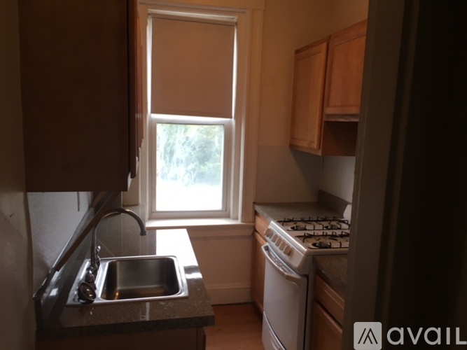 A kitchen with a sink, stove, and window.