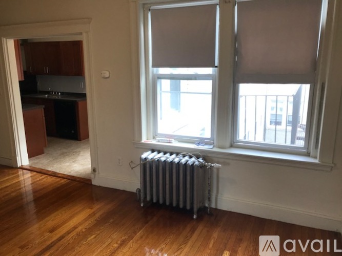 A room with a window and a radiator on the floor.