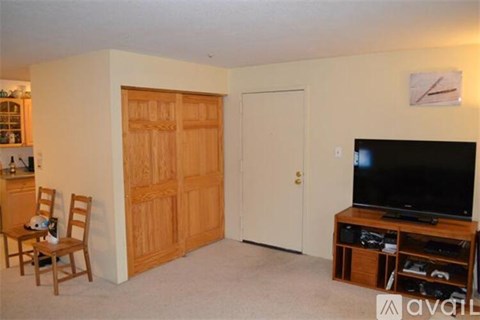 A living room with a television and a chair.