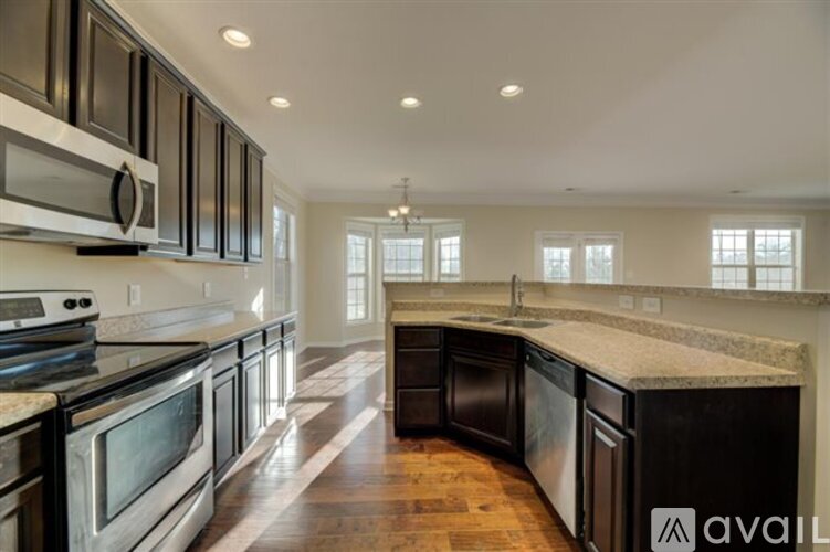 A kitchen with dark wood cabinets and stainless steel appliances.