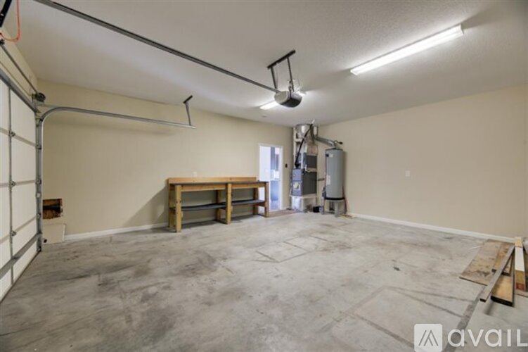 A spacious room with a concrete floor and a wooden table.