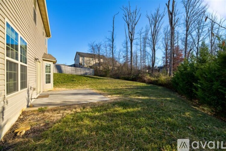 A house with a yard and trees in the background.