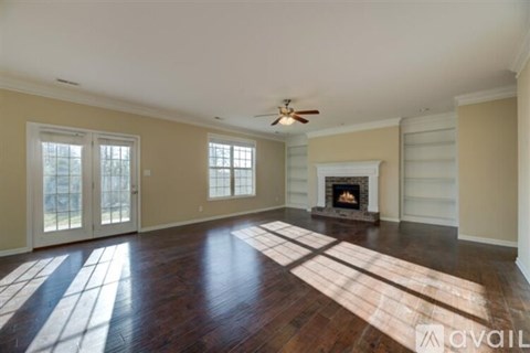 A living room with a fireplace and a rug on the floor.