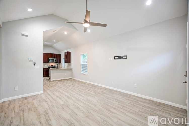 A spacious room with a ceiling fan and lighting fixtures.