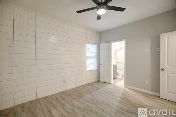 A room with a ceiling fan and tile walls.