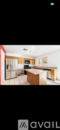 A kitchen with a refrigerator, oven, and sink.
