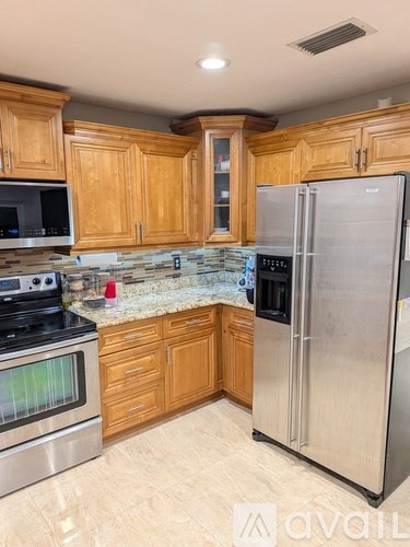 A kitchen with wooden cabinets and a granite countertop.