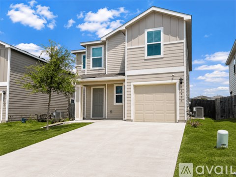 A two-story house with a garage and a driveway.