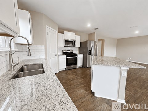 A kitchen with white cabinets and a granite countertop.