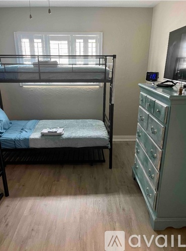A bedroom with a bunk bed and a chest of drawers.