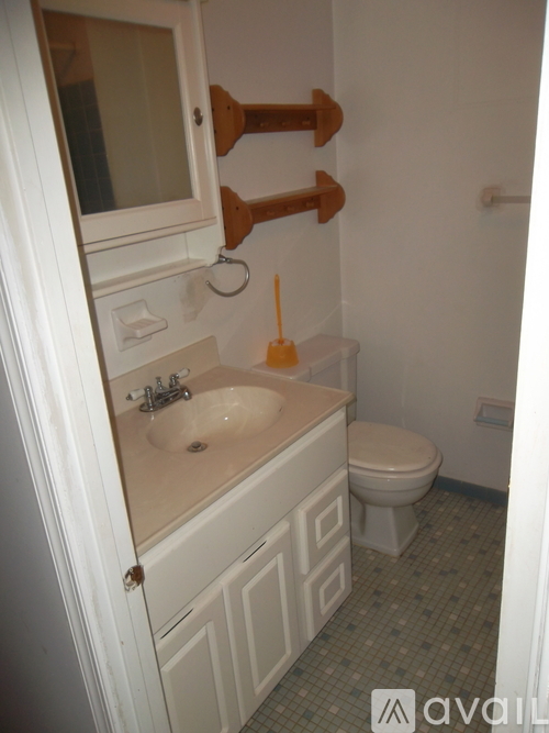 A bathroom with a toilet, sink, and towel rack.