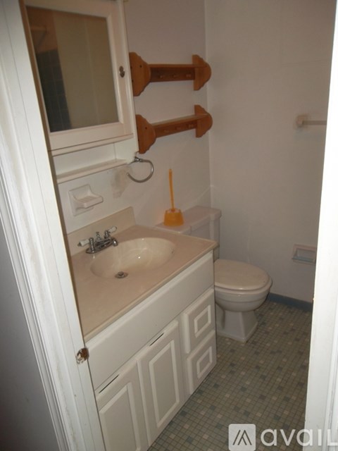 A bathroom with a toilet, sink, and towel rack.