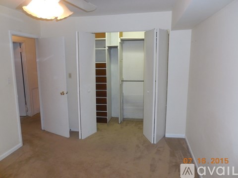 A room with a ceiling fan and a doorway leading to another room.