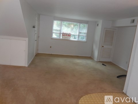 A room with a window and a door is available for rent.
