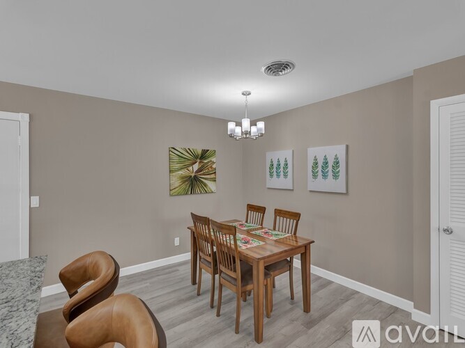 A dining room with a wooden table and chairs.