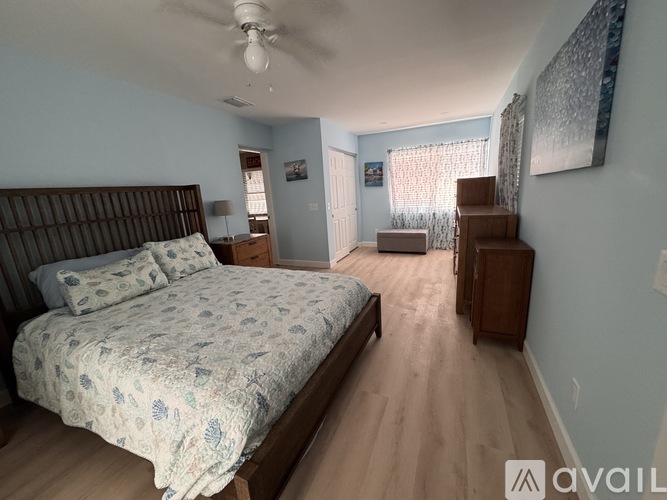 A bedroom with a large bed and a dresser.