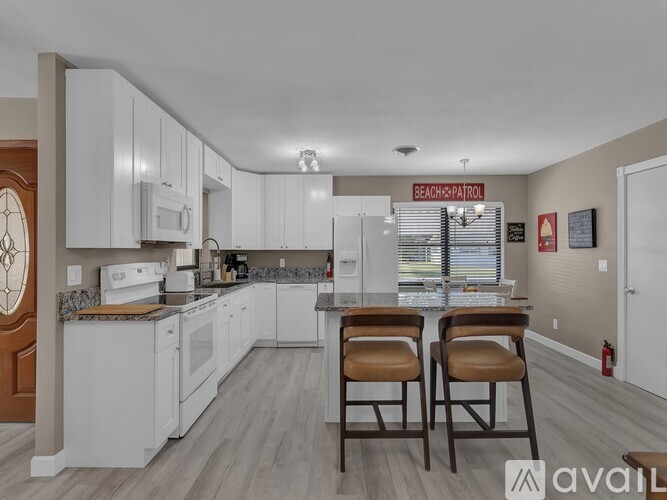 A kitchen with white cabinets and a sign that says "Beach Patrol".