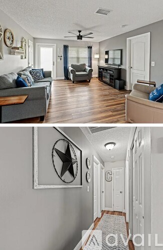 A living room with a grey couch and a wooden floor.