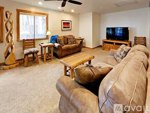 A living room with a brown couch and a wooden coffee table.