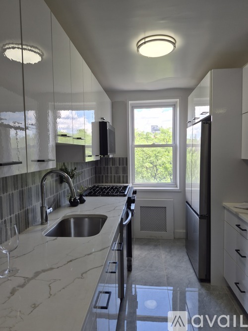 A modern kitchen with a marble countertop and stainless steel appliances.