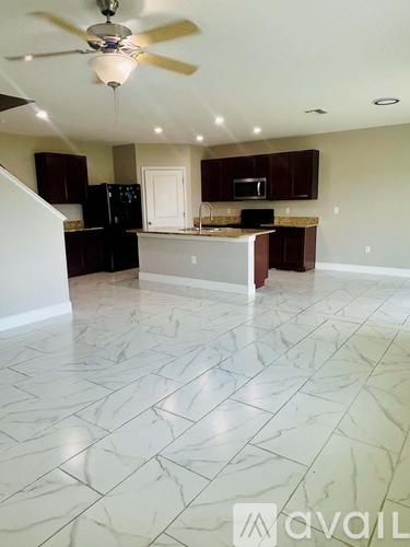 A kitchen with a marble floor and a ceiling fan.