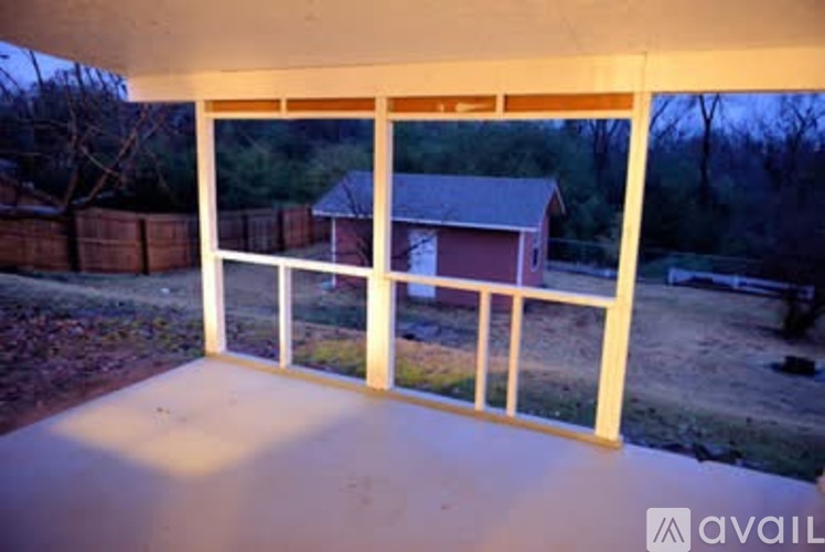 A balcony with a view of a house and trees.