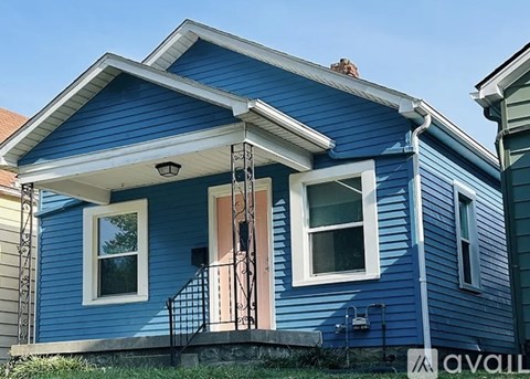 A blue house with a white window and a brown door.
