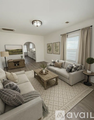 A living room with a grey couch and a wooden coffee table.