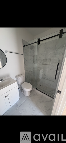 A bathroom with a toilet, sink, and shower.