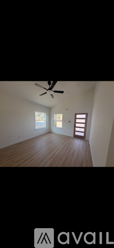 A room with wooden flooring and a ceiling fan.
