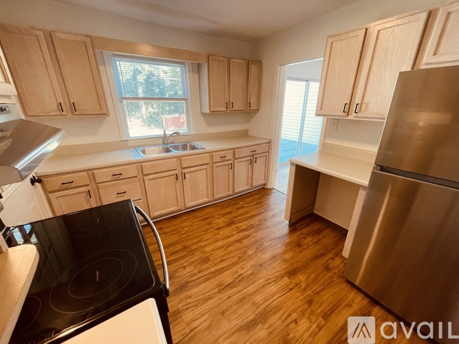 A kitchen with wooden cabinets and a stainless steel refrigerator.