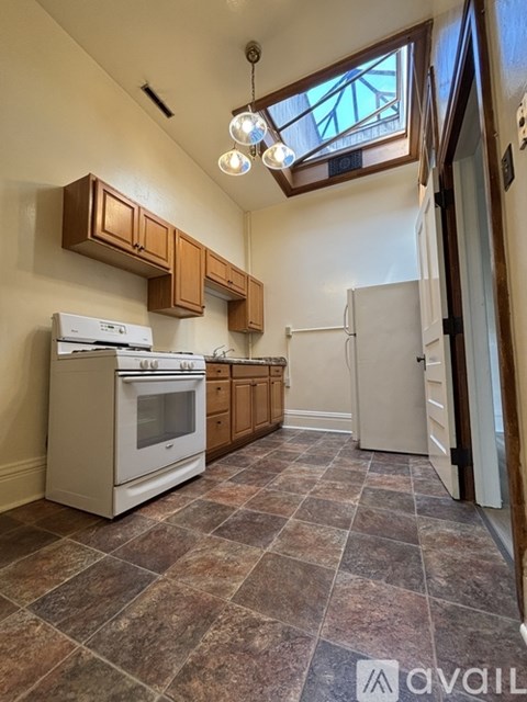 A kitchen with a white oven and a tiled floor.