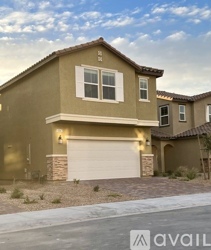 A house with a garage and a driveway in front of it.