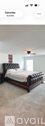 A bedroom with a bed and a ceiling fan.
