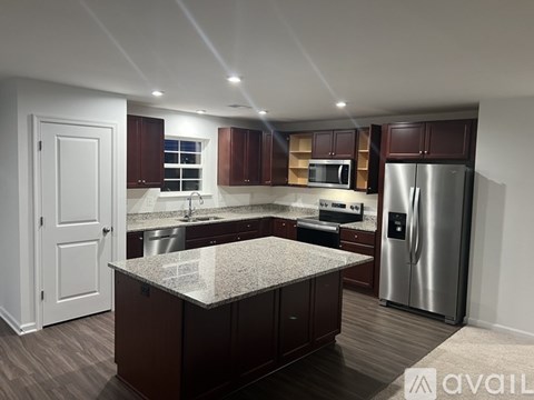 A kitchen with brown cabinets and a granite countertop.