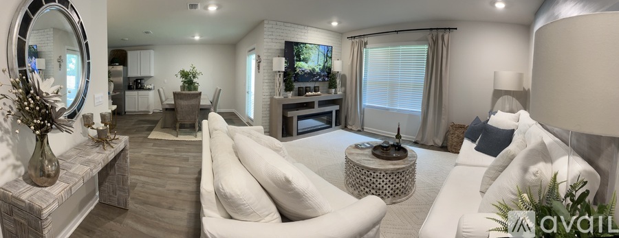 A modern living room with a white sofa and a round mirror on the wall.