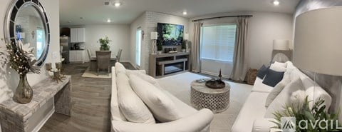 A modern living room with a white sofa and a round mirror on the wall.