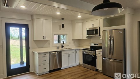 A kitchen with white cabinets and stainless steel appliances.