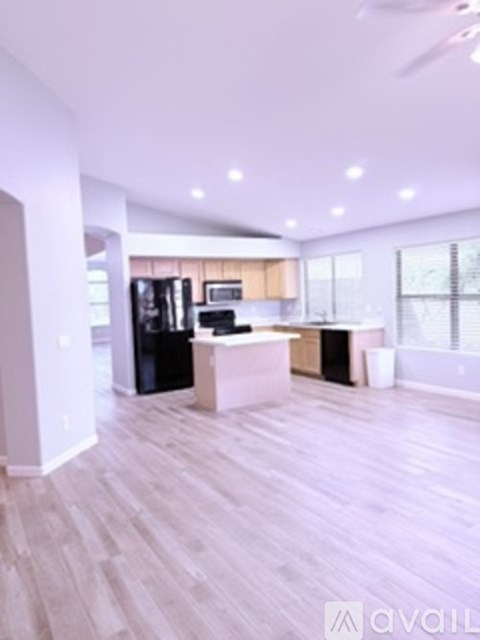 A spacious kitchen with light wood flooring and modern appliances.