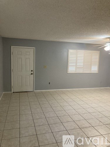 A room with a white door and a window with blinds.