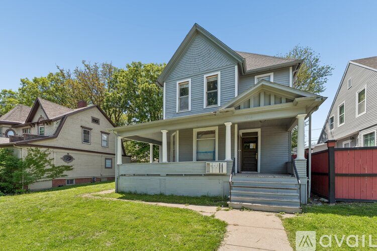 A two-story house with a front porch is for sale.