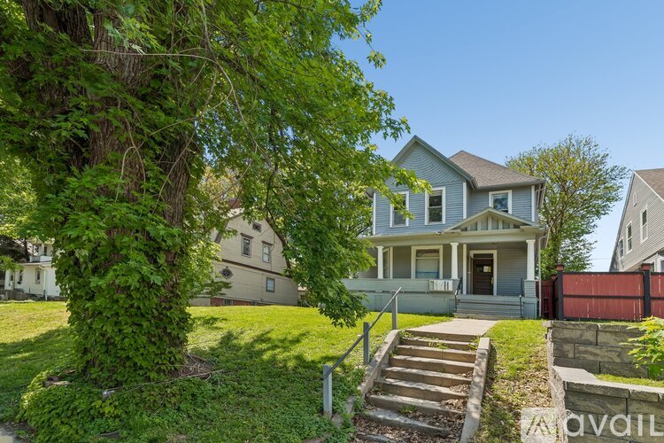 A house with a green lawn and a tree in front.