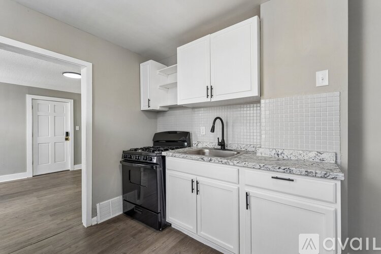 A kitchen with white cabinets and a black stove top oven.
