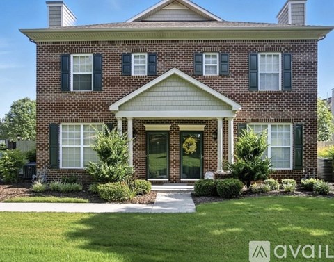 A brick house with a green lawn in front.