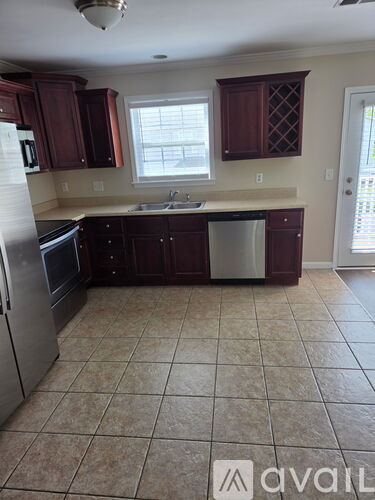 A kitchen with brown cabinets and a tiled floor.
